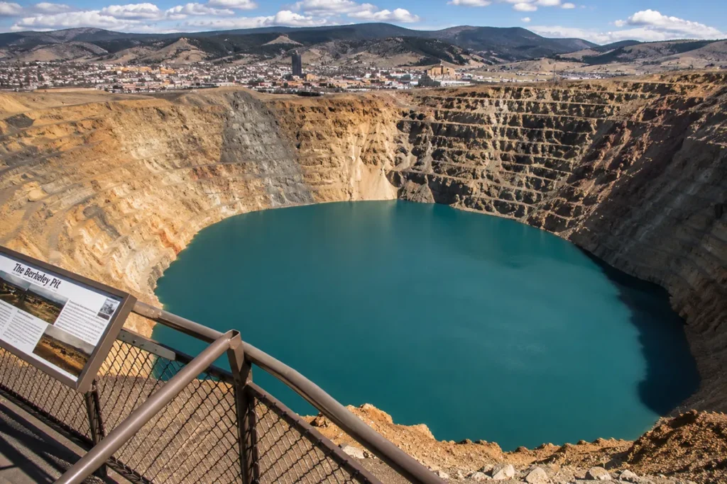 Historic Berkeley Pit observation stand with visitors looking down at the blue-green toxic lake below in Butte Montana