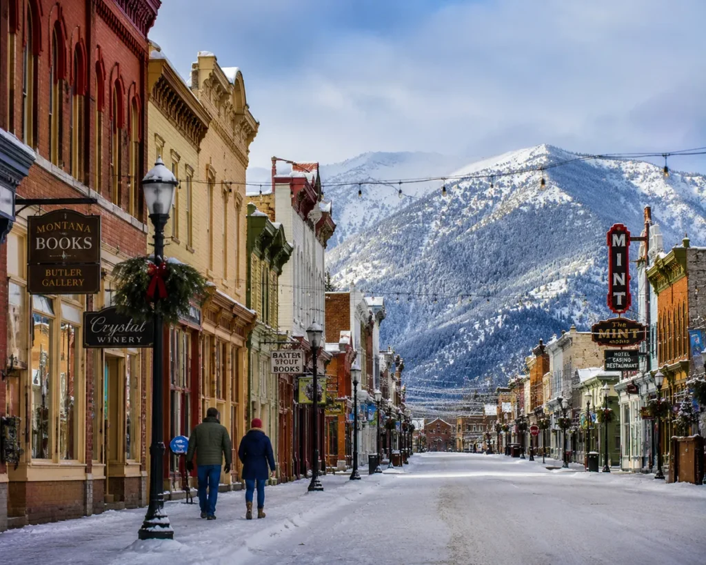 Historic main street of Philipsburg Montana in winter with snow on the colorful 1880s storefronts and Christmas lights still strung between buildings
