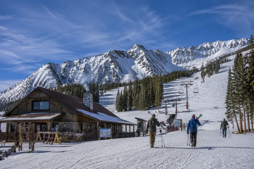 Wide angle view of a Montana ski resort base area on a bluebird winter day with mountains in the background