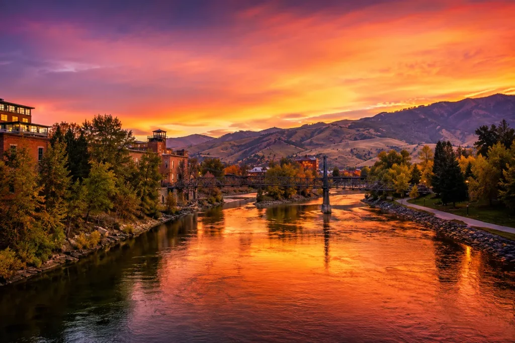 Sunset over the Clark Fork River in downtown Missoula Montana with the Higgins Avenue Bridge and colorful sky reflected in the water