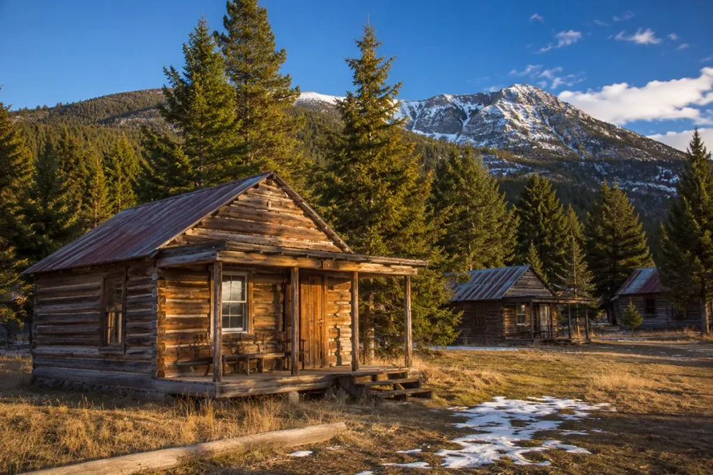Rustic log cabins at Elkhorn Hot Springs Resort surrounded by pine forest in the Pioneer Mountains Montana