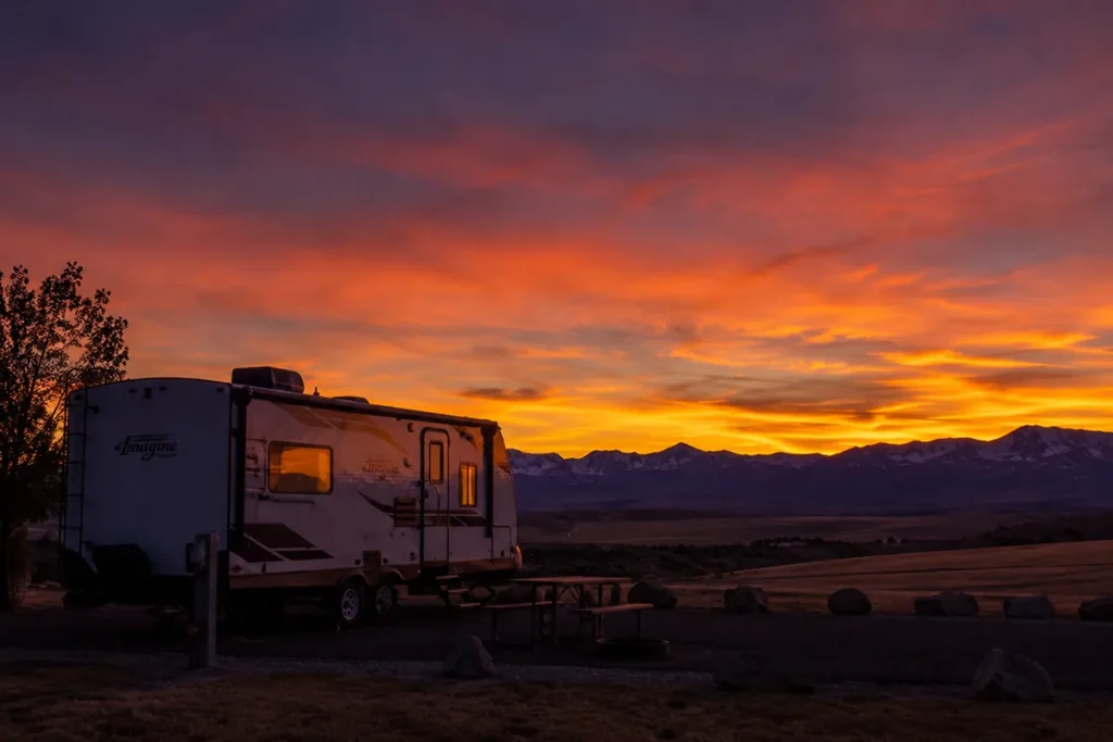 Sunset over a Montana RV park with the silhouette of a travel trailer