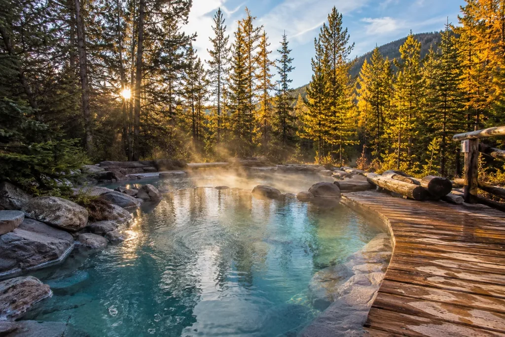 Natural hot springs pool at Lolo Hot Springs Montana surrounded by pine trees and mountains in fall
