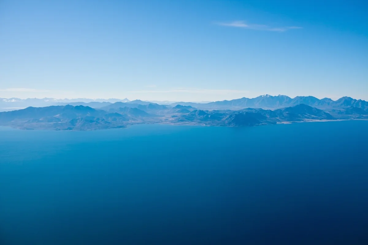 Aerial view of Flathead Lake with Mission Mountains in background, showing the lake's stunning blue color