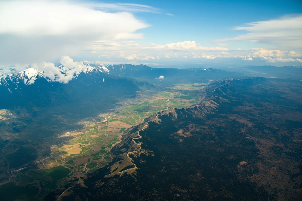 Aerial view of Montana landscape showing the contrast between mountain ranges in the west and plains in the east