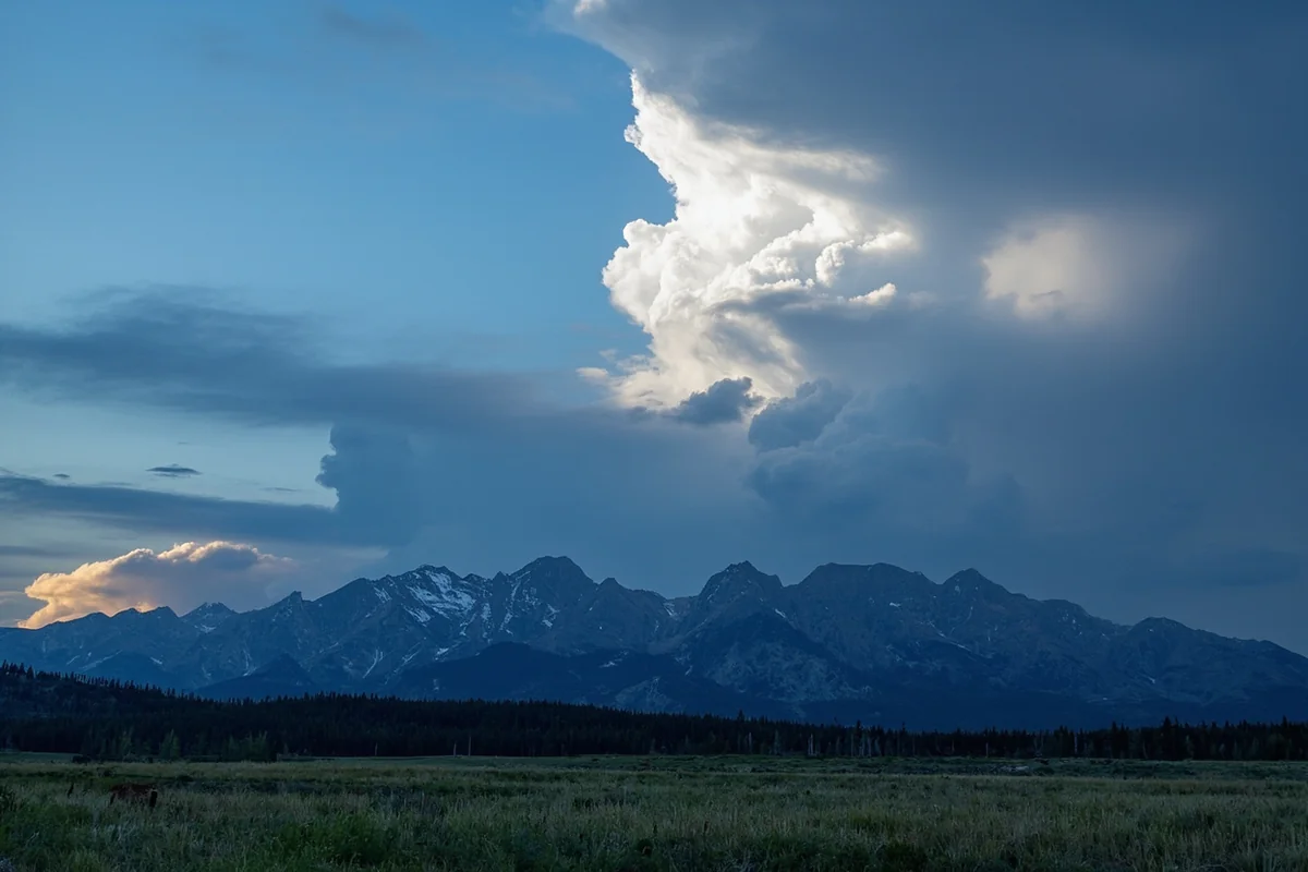 Afternoon thunderstorm building over Montana mountain range, showing dramatic cloud formation