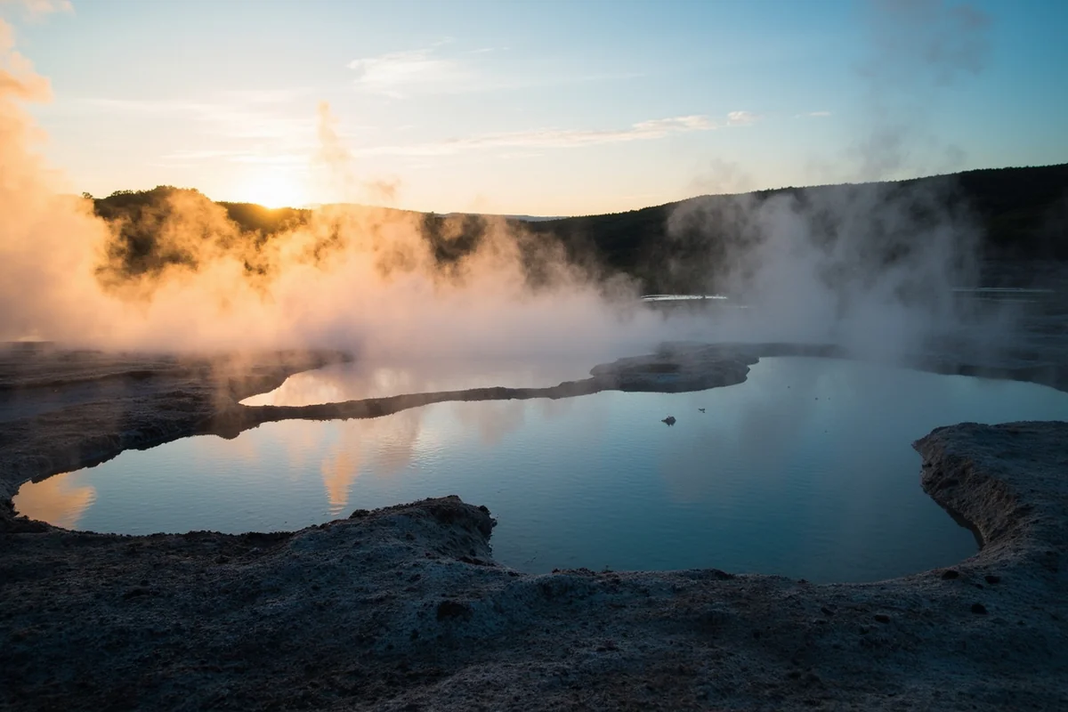 Atmospheric shot of steam rising from the pools at dawn, capturing the ethereal quality of the setting