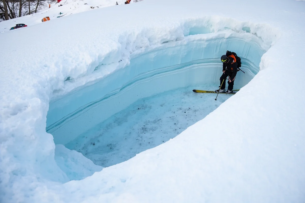Backcountry skier examining snow pit layers during avalanche assessment