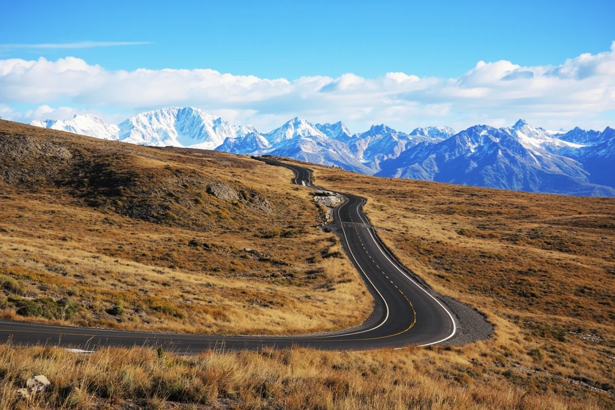 Beartooth Highway winding through alpine tundra with snow-capped peaks in background