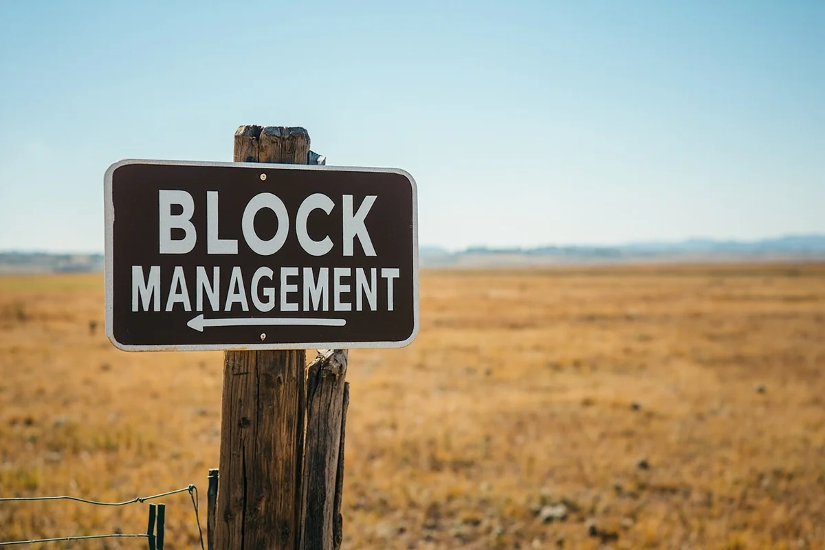 Block Management sign on a fence post with Montana prairie extending into the distance