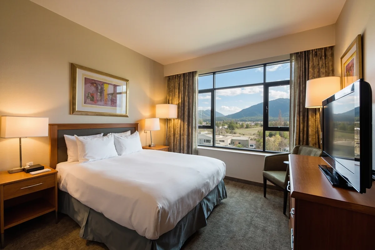 Budget-friendly hotel room interior in Missoula, clean and simply furnished with mountain views from the window