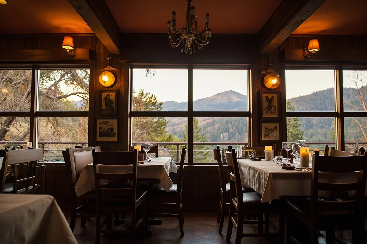 Chico Hot Springs dining room with vintage decor and mountains visible through windows