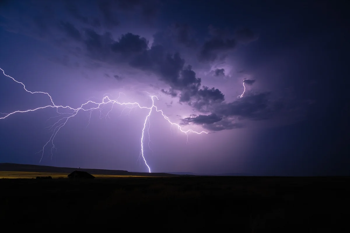 Dramatic lightning strike over Montana prairie during a summer thunderstorm at dusk