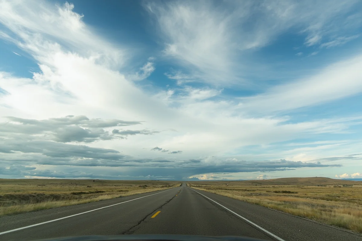 Empty Highway 2 (Hi-Line) in northeastern Montana with endless grassland and dramatic cloud formations