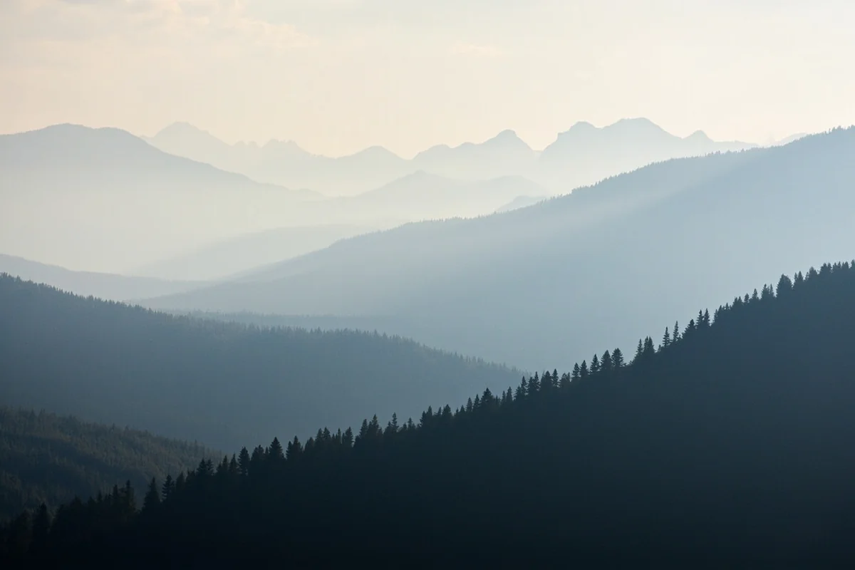 Hazy smoke obscuring mountain views in Glacier National Park during wildfire season