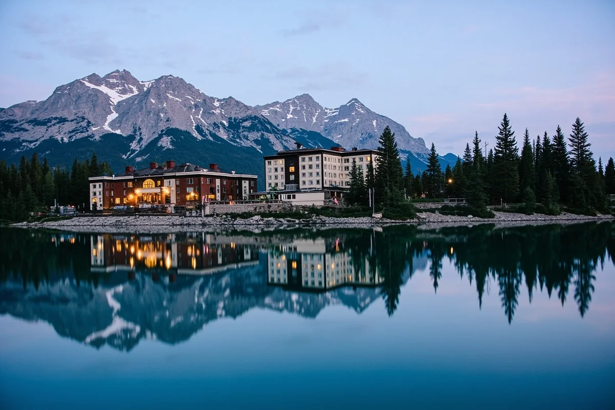 Historic Many Glacier Hotel reflected in Swiftcurrent Lake with mountains behind