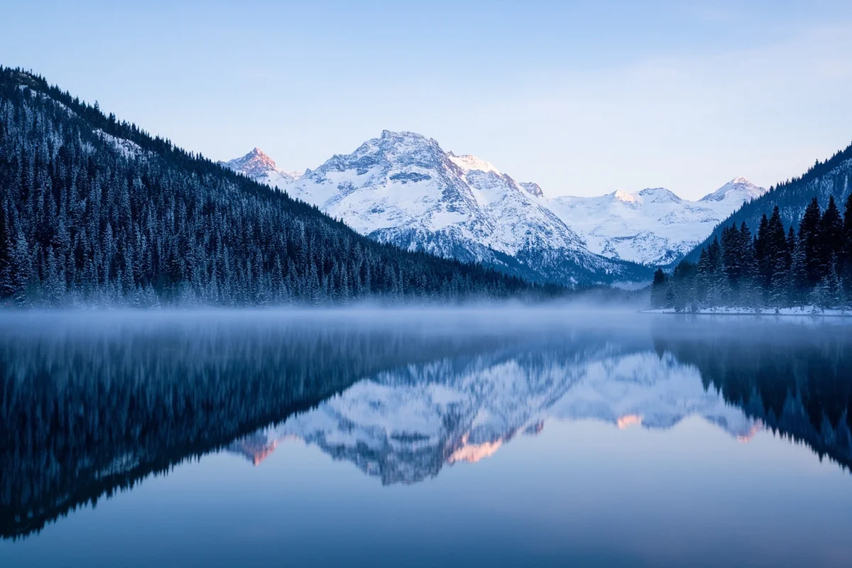 Lake McDonald in winter with snow-covered peaks, early morning reflection