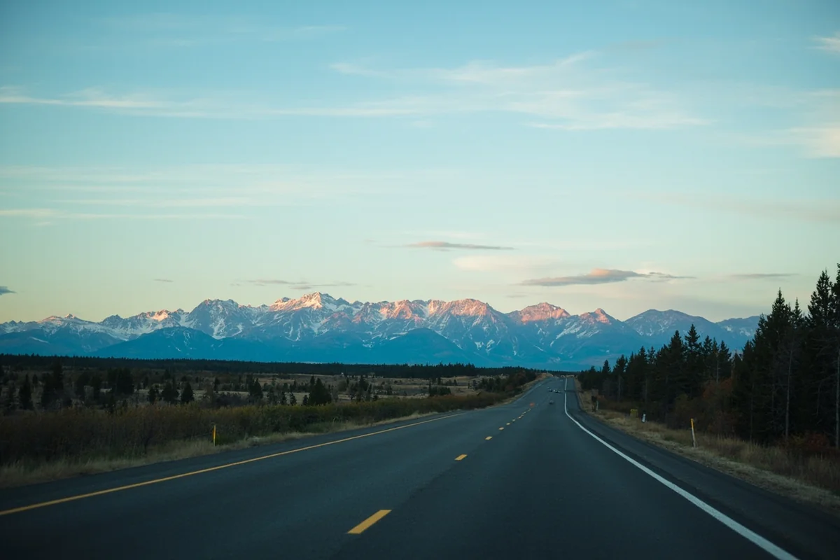 Long empty Montana highway stretching toward distant mountains