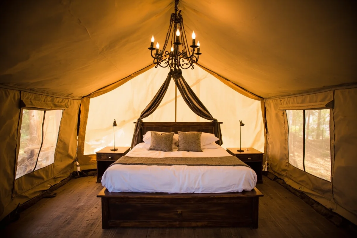 Luxury glamping tent interior with chandelier and comfortable bed at Paws Up Resort
