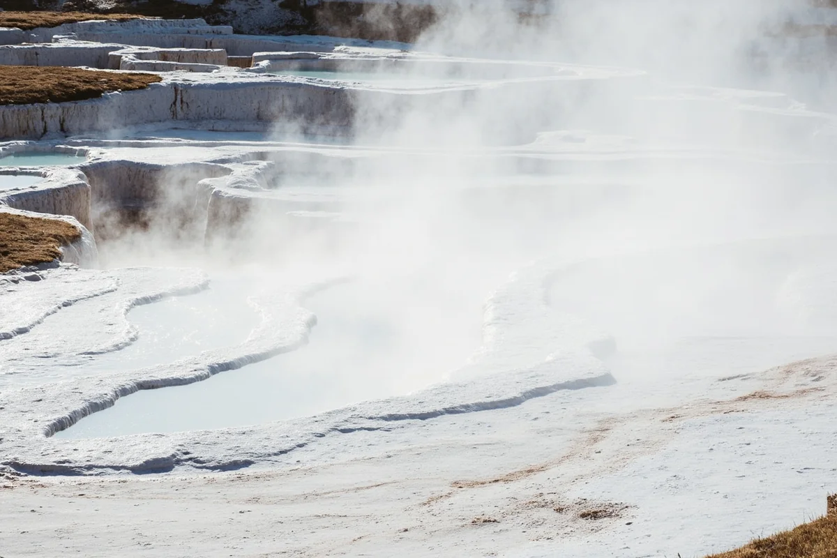 Mammoth Hot Springs terraces with steaming white travertine formations