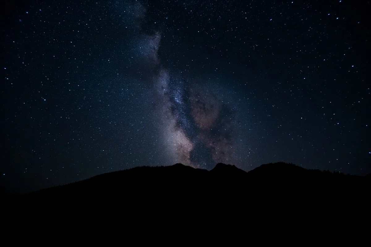 Milky Way galaxy visible over silhouetted Montana mountain peaks