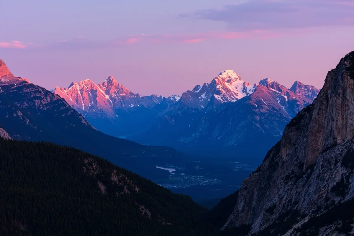 Panoramic view of Glacier National Park mountains at sunrise with alpenglow on peaks