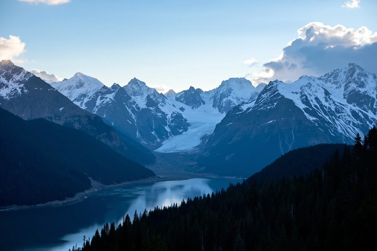 Panoramic view of Glacier National Park showing the Continental Divide with mountains, forests, and a glacial lake