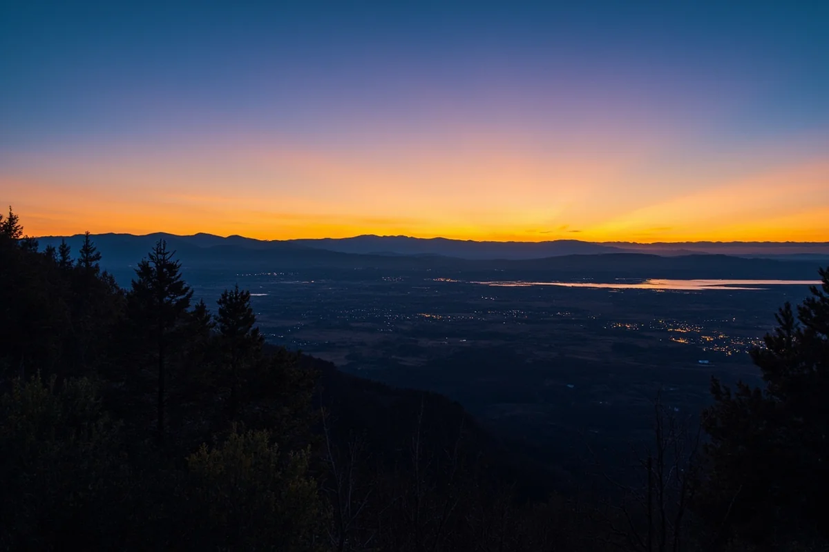 Panoramic view of Missoula valley from the M Trail at sunset with city lights beginning to twinkle
