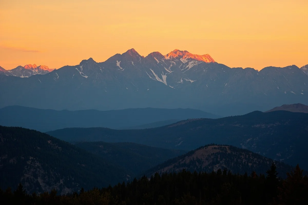 Panoramic view of Montana mountains at sunset with golden light illuminating peaks