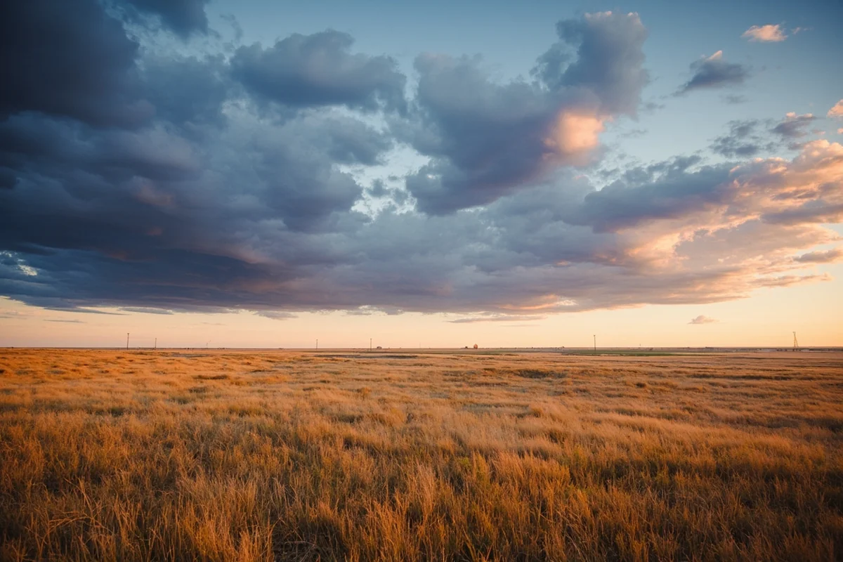 Rolling prairie landscape with distant pumpjacks and dramatic Montana sky