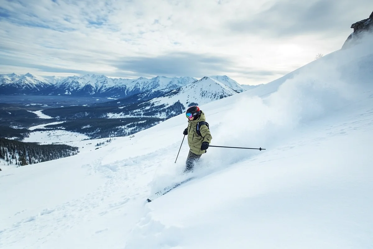 Skier in deep powder at Big Sky Resort with dramatic mountain backdrop
