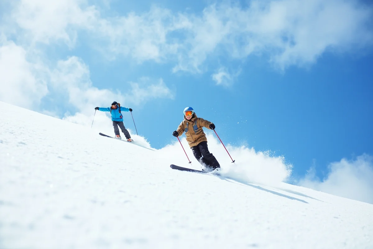Skiers enjoying spring skiing conditions with blue skies and soft snow
