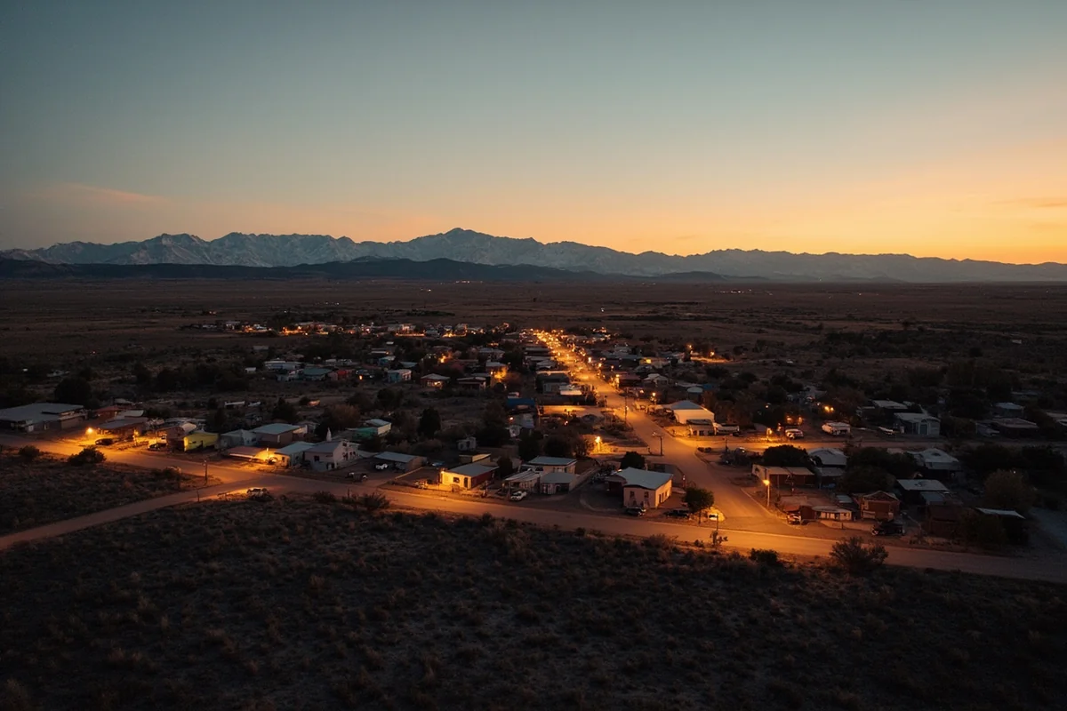 Small town of Wisdom at dusk with open ranchland and mountain backdrop