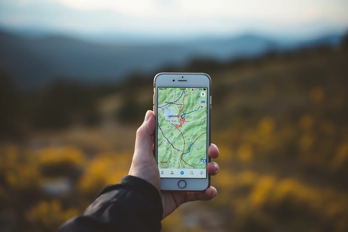 Smartphone displaying onX Maps hunting app with public land boundaries highlighted in mountainous terrain