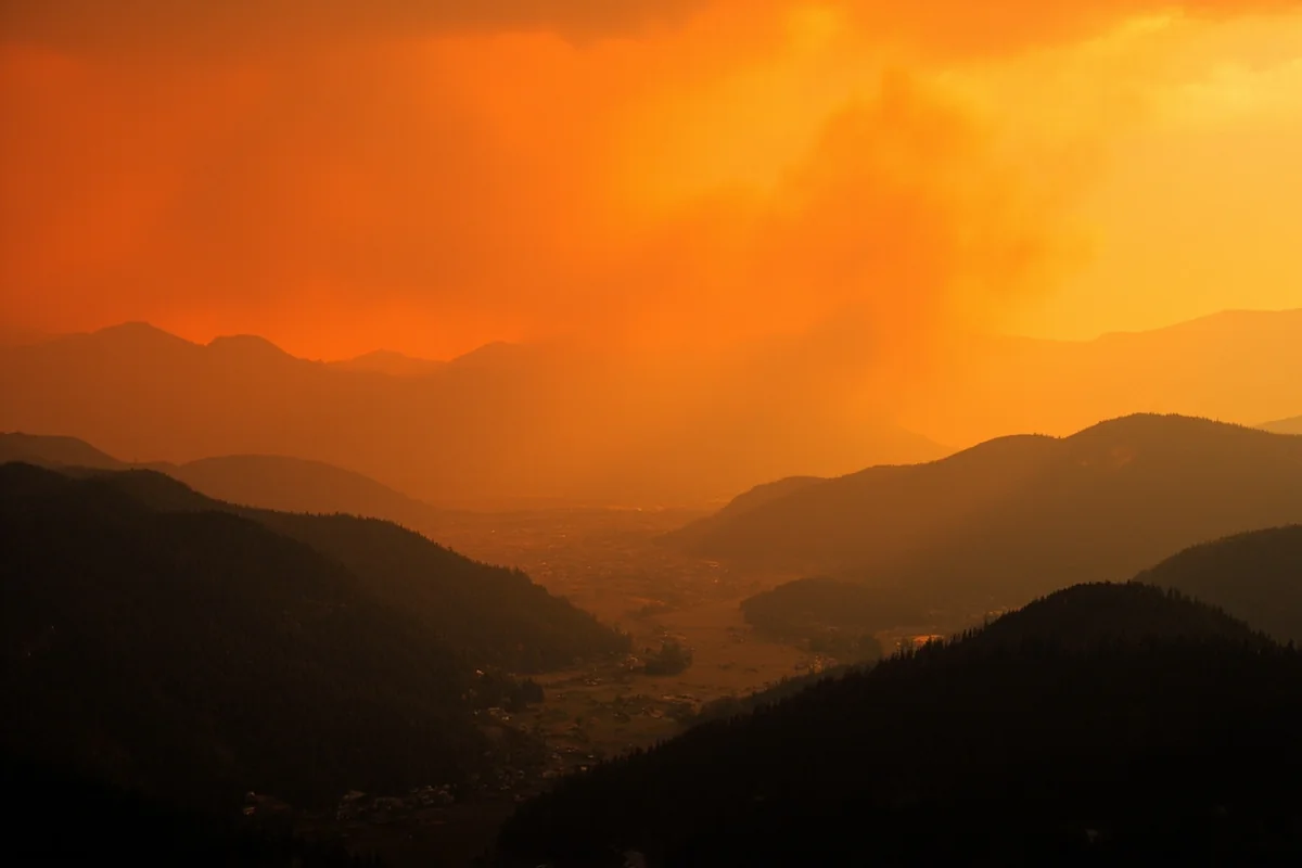 Smoky orange sky over Montana mountain valley during wildfire season