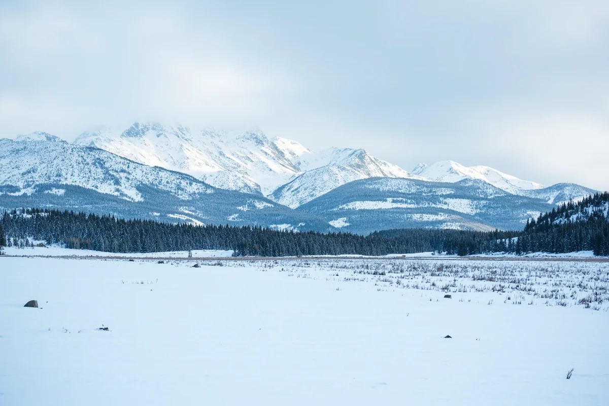 Snow-covered Montana landscape with mountain peaks in background during severe winter conditions