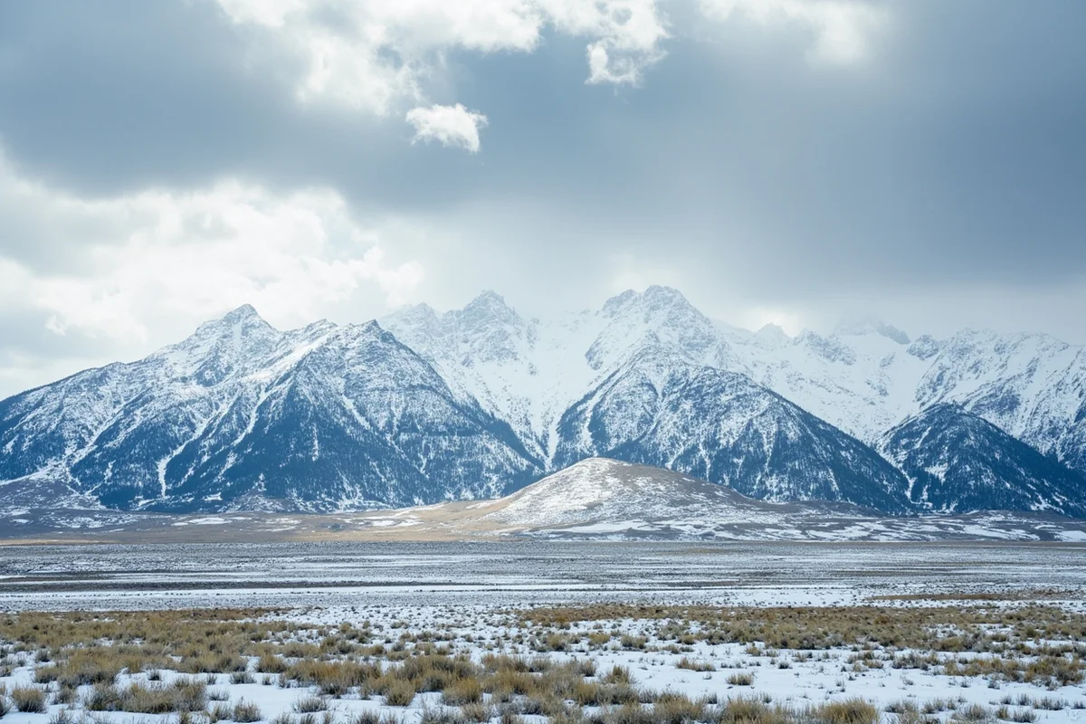 Spring snowstorm over Montana mountain range with patches of green grass emerging