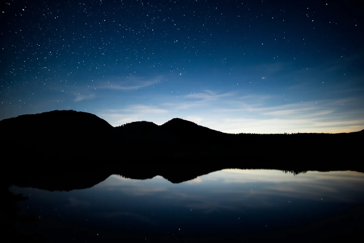 Star reflections in Two Medicine Lake with Sinopah Mountain silhouette