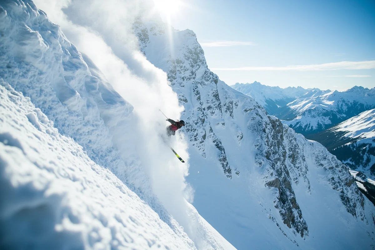 Steep chute with skier about to drop in, showing dramatic mountain terrain