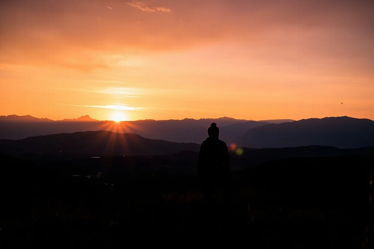 Sunset over Montana mountains with silhouette of person overlooking the landscape
