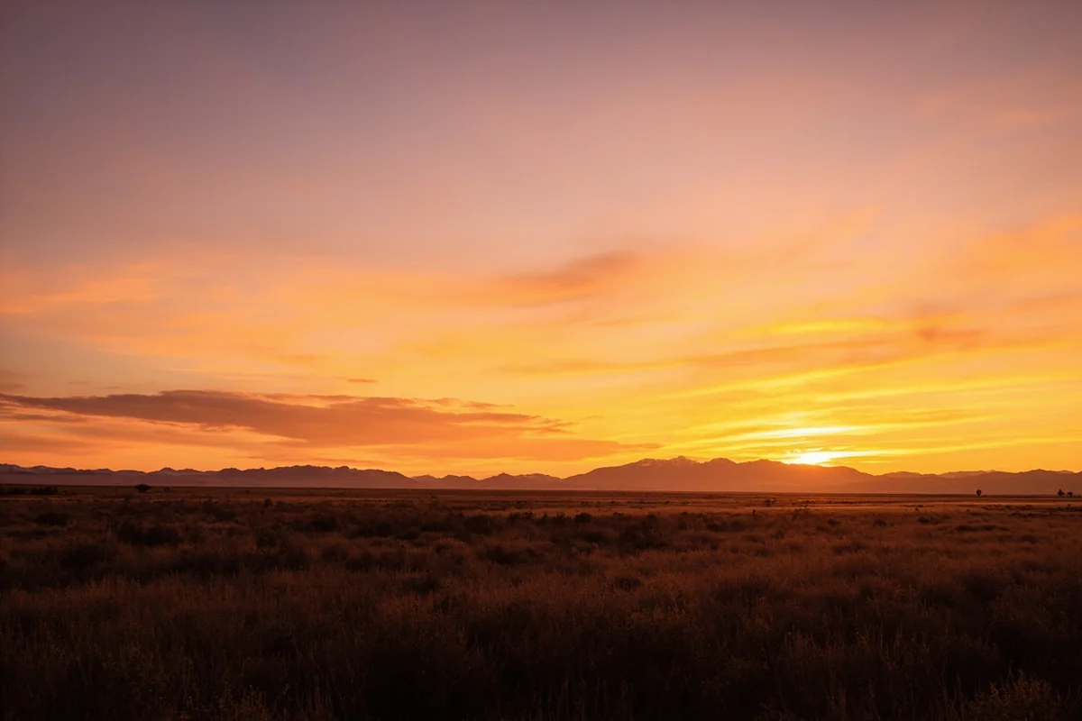 Sunset over Montana prairie with distant mountains and wide open sky