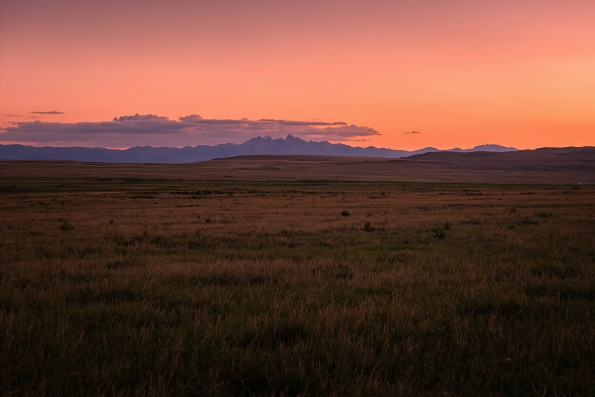 Sunset over Montana prairie with distant mountains on horizon