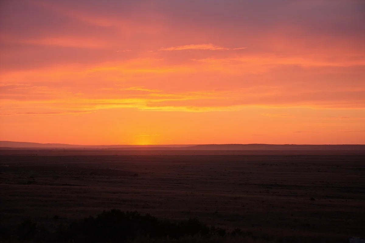 Sunset over the Montana plains with warm orange and pink skies