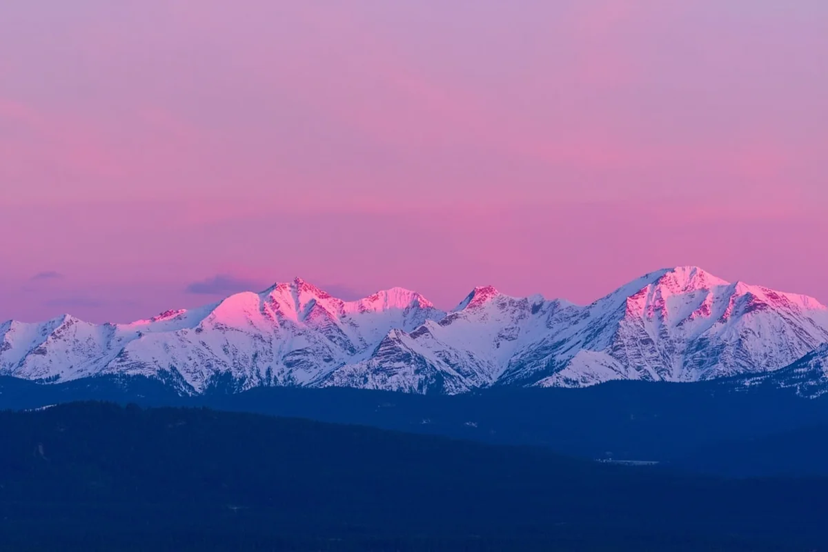 Sunset over Whitefish Mountain with pink alpenglow on snow-covered peaks