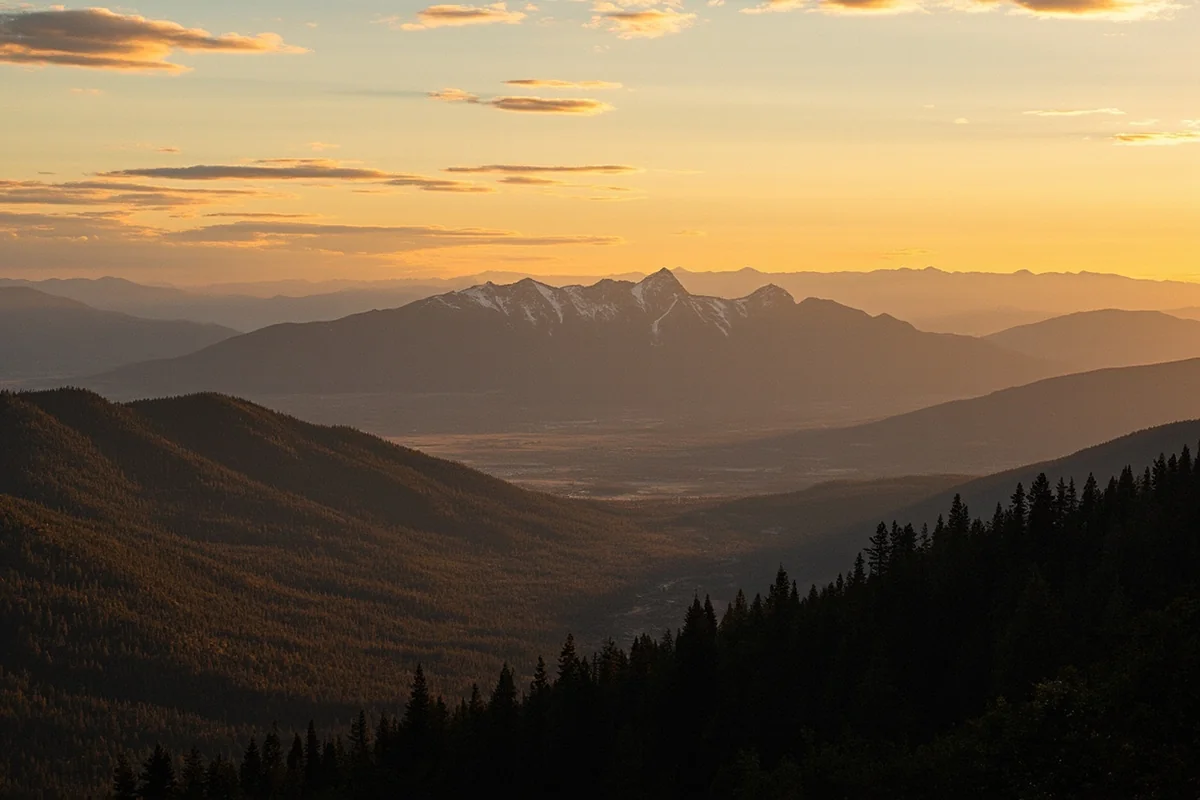Sweeping view of Montana mountain range at sunset with golden light across valleys