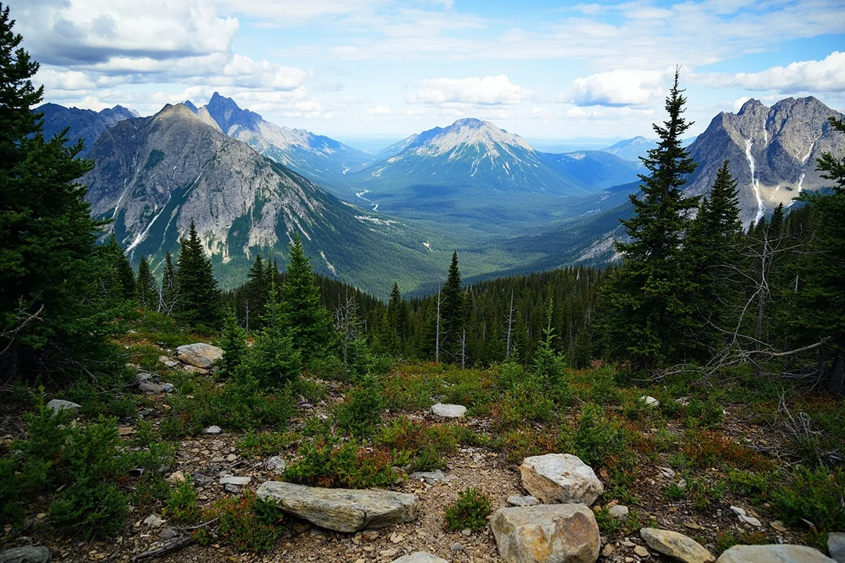 View of surrounding mountains from the Redrock Falls trail showing the broader Many Glacier landscape
