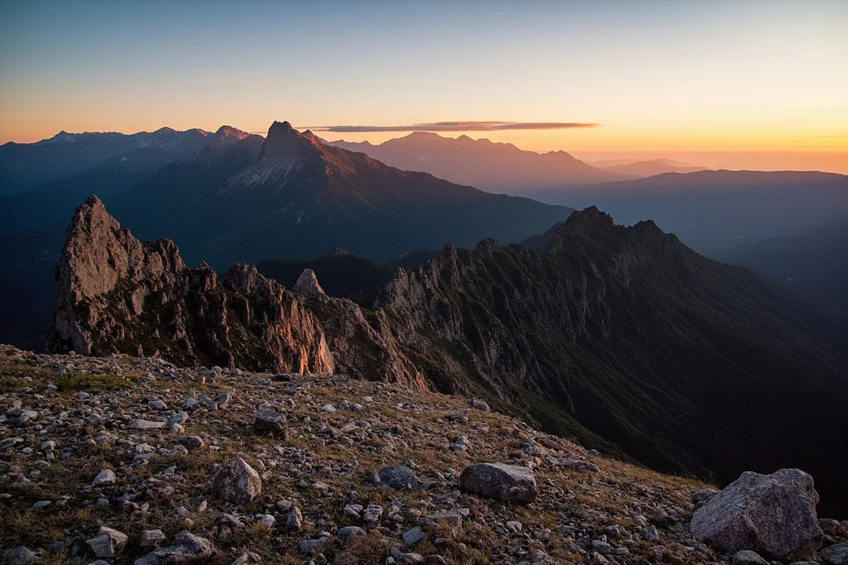 Wide landscape shot of Montana mountains with rocky terrain in foreground, golden hour lighting