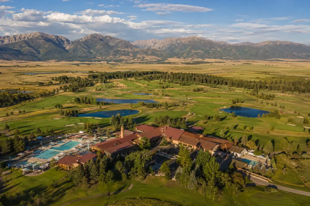 Aerial view of Fairmont Hot Springs Resort showing lodge buildings, pools, and surrounding Montana valley landscape