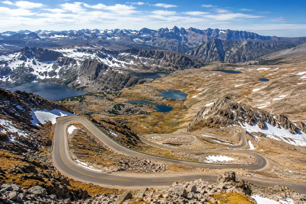 Switchbacks of the Beartooth Highway climbing into alpine terrain with snowfields and tundra