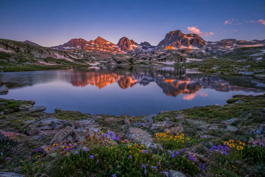 Alpine lake on the Beartooth Plateau with surrounding granite peaks at dusk